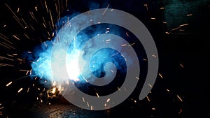 Welder welds a metal part, a lot of sparks and smoke, close-up, welding, close-up, industry