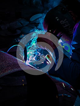 A welder welds pipes by emitting a beautiful glow