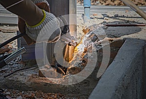 Welder welds steel wire and pole in construction site