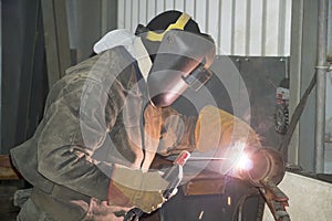 A welder welds technological pipelines with manual arc welding for an oil refinery in Russia. Welded joint