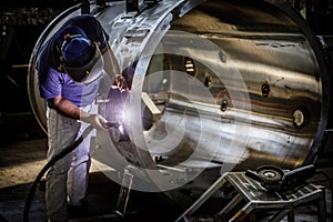 Welder at work in industrial environment