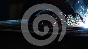 Welder at work. Welding of metal sparks and smoke in the workshop. Industrial Welder With gas Torch in Protective Helmet