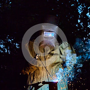 Welder worker welding metal by electrode