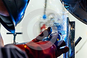 Welder worker welding a pieces of metal in the industrial factory, heavy weld industry concept