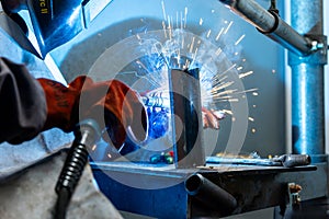 Welder worker welding a pieces of metal in the industrial factory, heavy weld industry concept