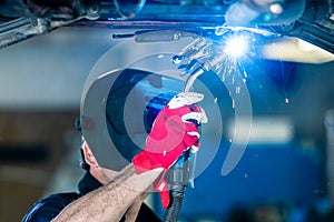 Welder working in car factory