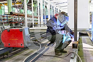 Welder is working at the factory and welding a metal construction