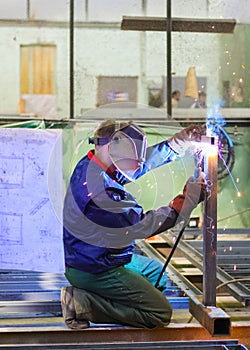 Welder is working at the factory and welding a metal construction