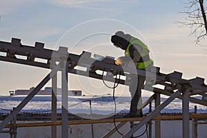 Welder working at height. Welding work on the construction. Iron construction