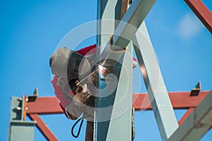 Welder works against the background of a blue cloudless sky
