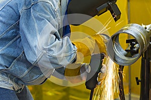 The welding craftsman grinding the steel tube