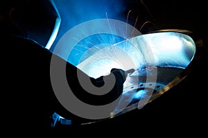 Welding a large metal wheel in a factory