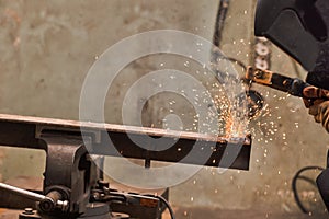 Welding Process With Sparks of Professional Male Welder in Protective Mask During Welding Process of Metal Rod At Factory