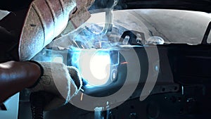Welding steel with electricity in auto body repair shop, closeup
