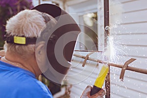 Welding worker repairing metal construction