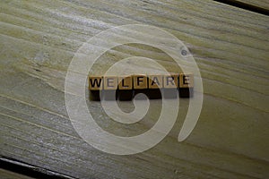 Welfare word on wooden blocks isolated on wooden table