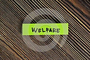 Welfare write on sticky notes isolated on Wooden Table