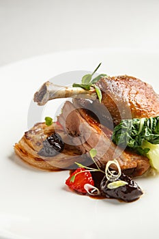 Well-browned and crisp duck confit with roast fennel, citrus fruit and prune sauce. Roasted Duck leg. White dish