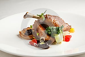 Well-browned and crisp duck confit with roast fennel, citrus fruit prune sauce. Roasted leg. White dish
