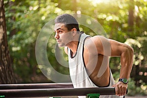 Well built muscular man doing a physical exercise outdoors