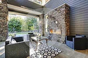 Well designed covered patio boasts stone fireplace