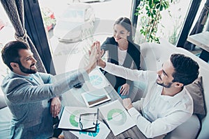 Well done! Success and team work concept. High angle view of three business partners are amazed, sitting at the terrace of a cafe