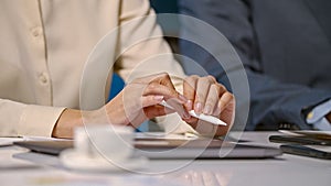 Well-dressed negotiating professionals sitting at desk in office