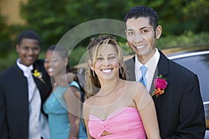 Well-dressed teenage couple outside car portrait photo