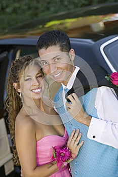 Well dressed teenage couple outside limo portrait