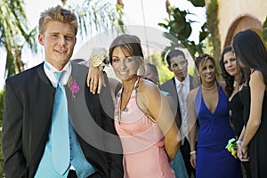 Well-dressed teenage couple standing outside school dance