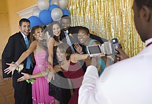 Well-dressed teenagers posing for video camera at school dance
