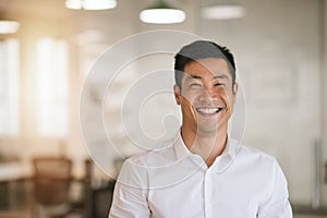 Smiling Asian businessman standing in a bright modern office