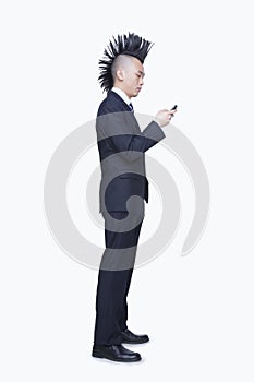 Well-dressed young man with Mohawk using mobile phone