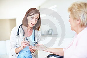 Well get to the bottom of your faintness - DiabetesSenior Care. Mature nurse checking an elderly patients blood sugar photo