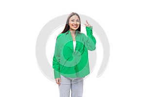 well-groomed attractive young brunette woman with makeup in a green shirt on a white background with copy space