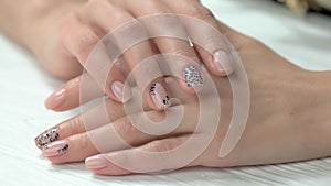 Well-groomed female hands with nude manicure.