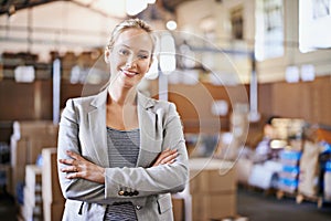 Well handle all your logistical needs. Portrait of a young woman standing in a distribution warehouse.