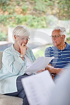 Well have to think about it...Over-the-shoulder shot of a financial advisor meeting with a senior couple at their home.