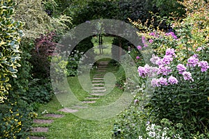 Well kept garden with lawn, stepping stones and well stocked flower beds. Oxford, UK.