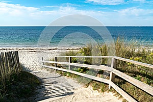 Well-kept wooden beach access leading through sand dunes to an empty beach