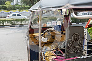 Well known and famous local taxi in Thailand, Tuk-Tuk, parking nearby tourist place, waiting for passengers asking for a ride.