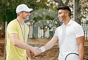 Well played. a handsome young male tennis player shaking hands with his coach outside on the court.