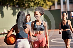 Well played. Low angle shot of a diverse group of friends huddled together after playing basketball during the day.