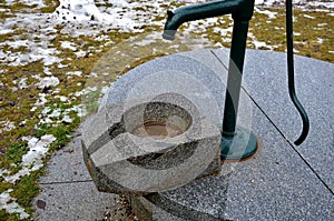 Well with polished sleek stone lid. from a hand pump water flows into a stone trough with a gutter. pure stone production. custom