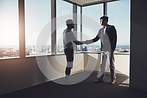 Well rise to greater heights together. Shot of two businessmen shaking hands in an office.