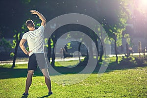 Well shaped athlete working out in park