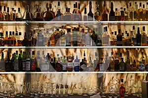 Well stocked bar with various alcoholic bottles and glasses