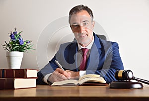 Well-suited lawyer signing on his desk