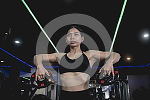 An well trained woman performs upright rows with 2 barbell plates. Variation on a common exercise for traps. Working out at the