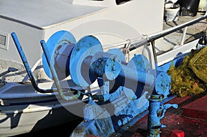 well-used and strikingly coloured mechanical fishing gear on a traditional wooden Greek fishing boat.